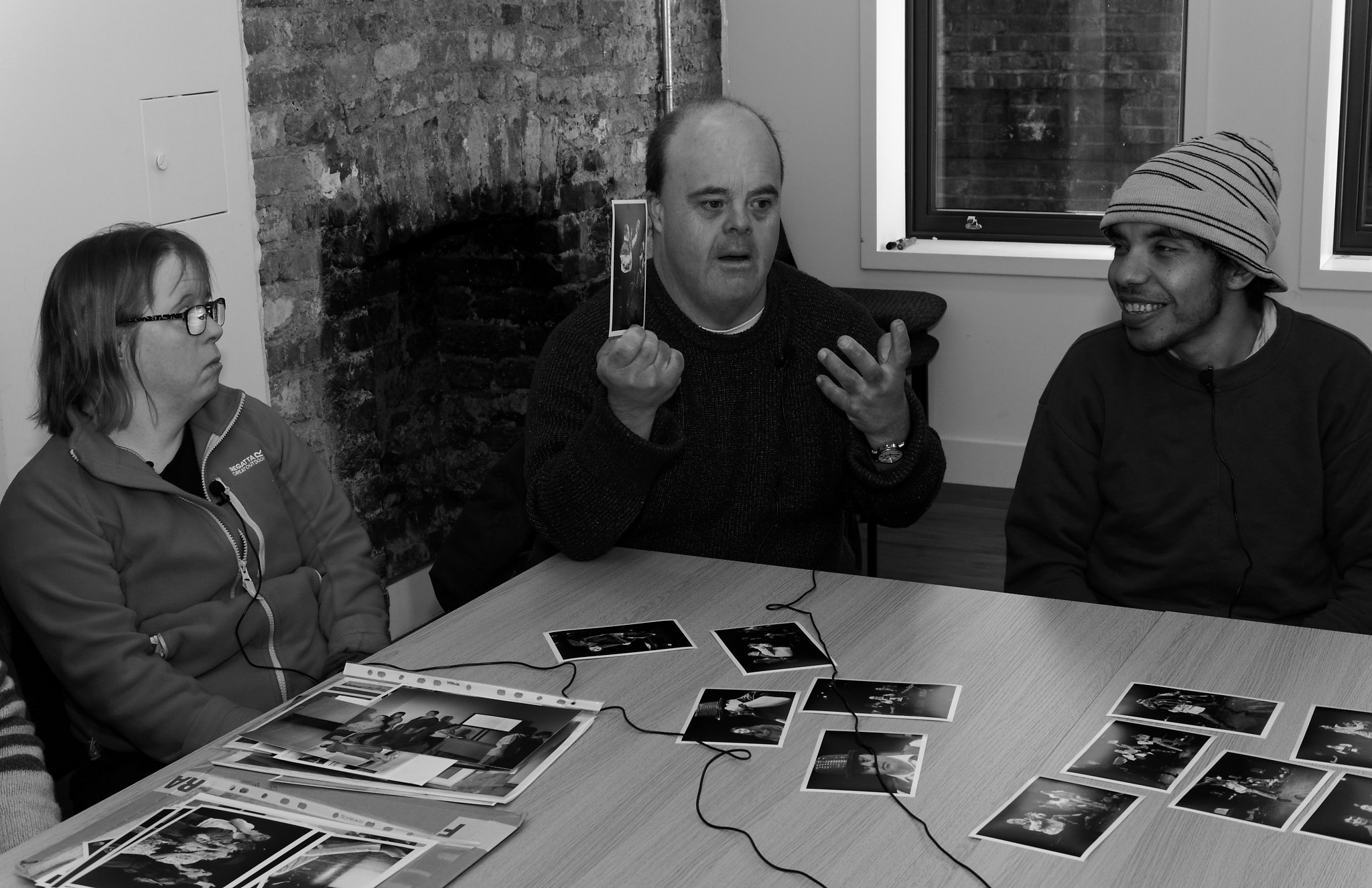 Black and white photo of Graham discussing photos with other dancers at interview